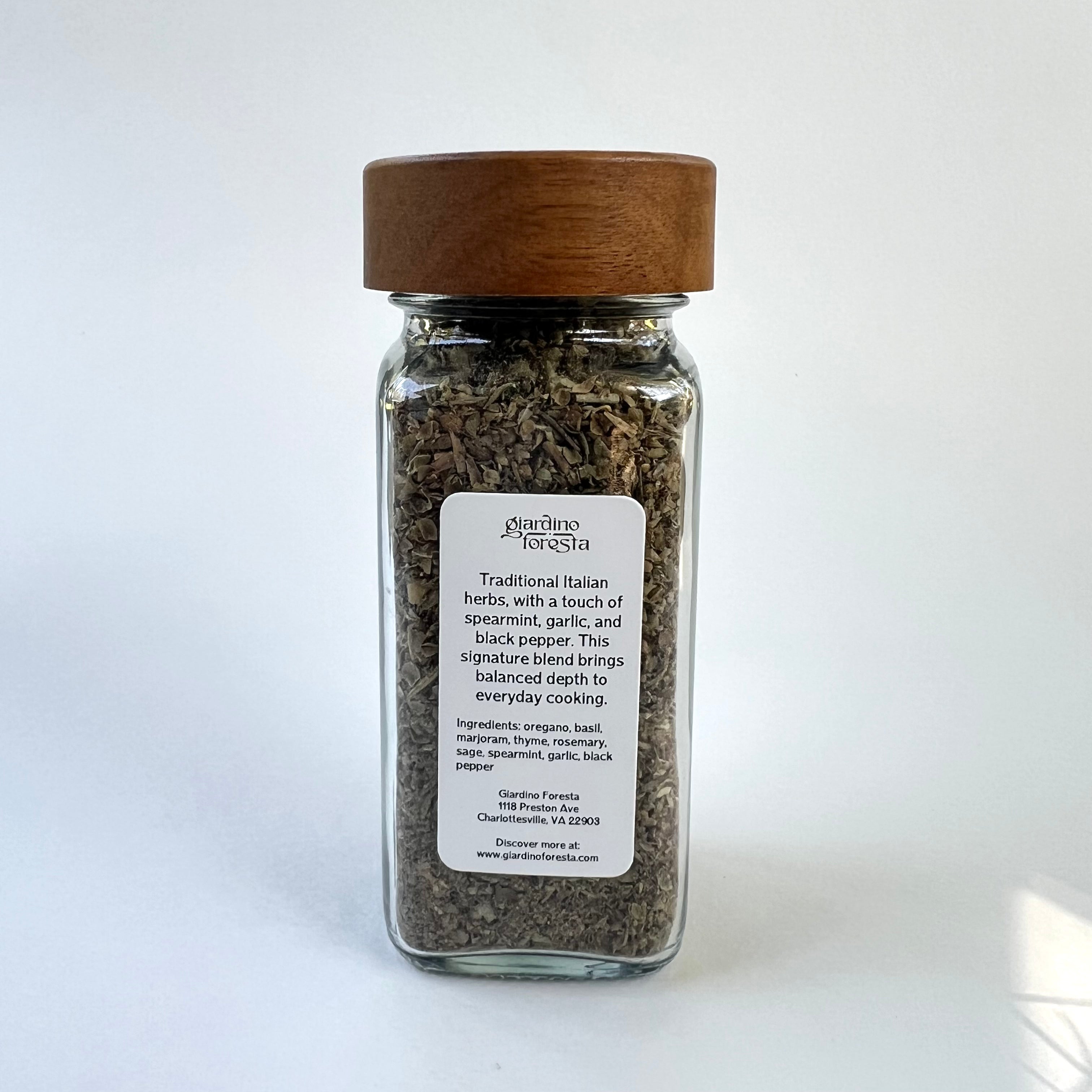 A glass spice jar with a wooden lid and a white label reading on a clean white background.