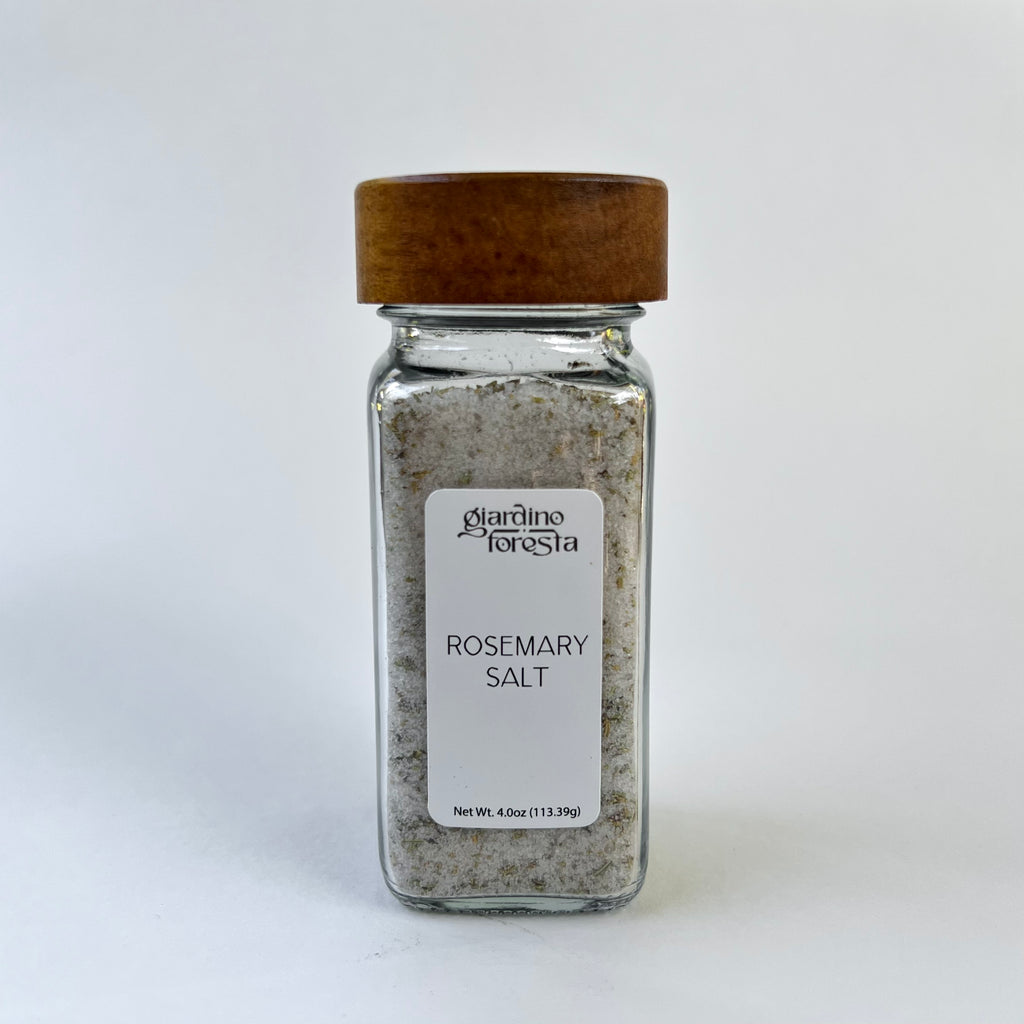 A square glass spice jar filled with seasoning salt, featuring a white label with the brand name 'Giardino Foresta' and a dark brown wooden lid, set against a white background.